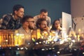 Double exposure of young people working in office and illuminated city at night