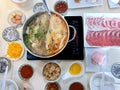 Double flavor hot pot with vegetables in tom yum soup and raw pork sliced, garlic fried rice, egg and spicy seafood dipping sauce Royalty Free Stock Photo