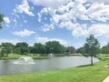 Two floating fountains at residential park with clean pond surrounded by large trees in Coppell, Texas, USA Royalty Free Stock Photo