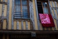 Double floral pink blanket hanging from a window of a building