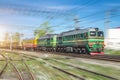 Double freight train green locomotive and on the forks of the railway tracks. Royalty Free Stock Photo
