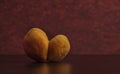 Double fresh apricots on black table with red background