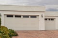 Closed garage door with windows. Double garage with short driveway in day
