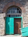 Double green wooden door with broken leaf Royalty Free Stock Photo