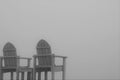 Offset silhouette of two wooden chairs against foggy sky