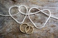 Double heart shaped rope and a double gold ring Royalty Free Stock Photo