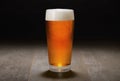 Double India pale ale beer served in a chilled pint glass on wooden counter at a craft beer pub, black background Royalty Free Stock Photo