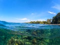 Double landscape with sea and sky. Sea panorama split photo. Undersea view with tropical island seashore. Royalty Free Stock Photo