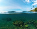 Double landscape with sea and sky. Split photo with tropical island and underwater coral reef. Royalty Free Stock Photo