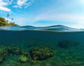 Double landscape with sea and sky. Split photo with tropical island and underwater coral reef. Royalty Free Stock Photo