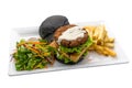 Double patty burger with Quinoa Tofu and Nyonya Otah, fries and salad served in dish isolated on plain white background side view