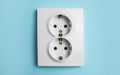 Double power socket on light blue wall. Electrical supply Royalty Free Stock Photo