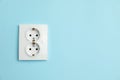 Double power socket on light blue wall, space for text. Electrical supply Royalty Free Stock Photo