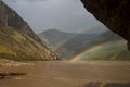 Double rainbow above the muddy river in the mountains. Royalty Free Stock Photo