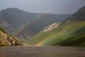Double rainbow above the muddy river in the mountains. Royalty Free Stock Photo