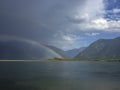 Double rainbow above river with mountains and cloudy sky Royalty Free Stock Photo