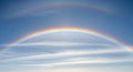 Double rainbow arches across a light blue sky with thin white clouds in the background of the image Royalty Free Stock Photo