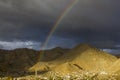 A double rainbow in the dark evening sky over the village in a mountain desert valley Royalty Free Stock Photo