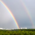 Double rainbow over forest and city in spring Royalty Free Stock Photo