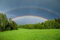 Double rainbow over a green grass meadow field Royalty Free Stock Photo