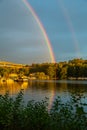 Double rainbow over water and city. Royalty Free Stock Photo