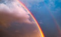 Double rainbow in the sky with clouds and birds