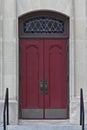 Double red doors with stained glass window above. Royalty Free Stock Photo