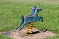 Double retro vintage old dilapidated public playground equipment in shape of pony spring rider swing with plastic handles and