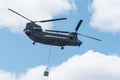 Double rotor, heavy airlift, military helicopter, in flight, carrying cargo.