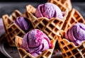 A double scoop of pink and purple ice cream in a waffle cone.