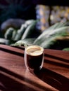 Double Sided Wall Glass Cup of Americano Coffee on Wooden Table at Garden