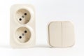 double socket and two-key light switch on white background.