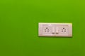 Double Sockets for electrical appliances on a green wall background. all purpose switch on a wall socket Royalty Free Stock Photo