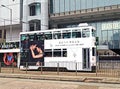 Double-storey tram at the stop in front of the main building of the HSBC Bank in Hong Kong