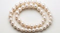 A double strand of white pearls on a white background. The pearls are round, lustrous, and uniform in size. The necklace