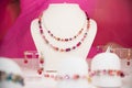 Double-stranded gemstone necklace and matching earrings on a white display stand