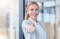 Double tap if you love what we do. Portrait of a mature businesswoman showing thumbs up in a modern office. Royalty Free Stock Photo