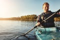 When in doubt kayak on. a young man kayaking on a lake outdoors.