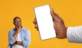 Doubtful Black Man Looking At Blank Cellphone In Big Male Hand