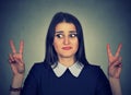 Doubtful confused woman with victory sign Royalty Free Stock Photo