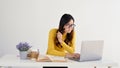 A doubtful Asian female student is looking at her laptop screen with hesitation Royalty Free Stock Photo