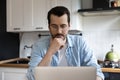 Doubtful man working from home pondering on data on screen Royalty Free Stock Photo