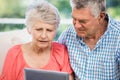 Doubtful senior couple using tablet