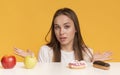 Doubtful Woman Choosing Between Healthy And Unhealthy Food, Fruits And Sweets