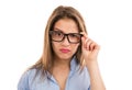 Doubtful woman looking at camera through eyeglasses Royalty Free Stock Photo