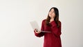 A doubting and thoughtful Asian female college student stands against an isolated white background Royalty Free Stock Photo