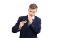 Doubting young attractive businessman trader holding bitcoin cryptocurrency, isolated on white Royalty Free Stock Photo