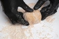 The dough ball is kneaded by a man in black gloves. Close up Royalty Free Stock Photo