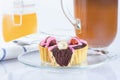 Dough baskets with chocolate and hazelnuts, pink iced cakes. Coffee in an Irish coffee glass, orange jam in a jar with a yoke. Lin