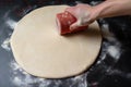 dough being rolled out into thin, circular shape for pizza
